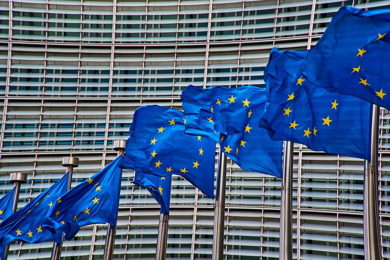 Flagi Unii Europejskiej na tle siedziby Komisji Europejskiej
