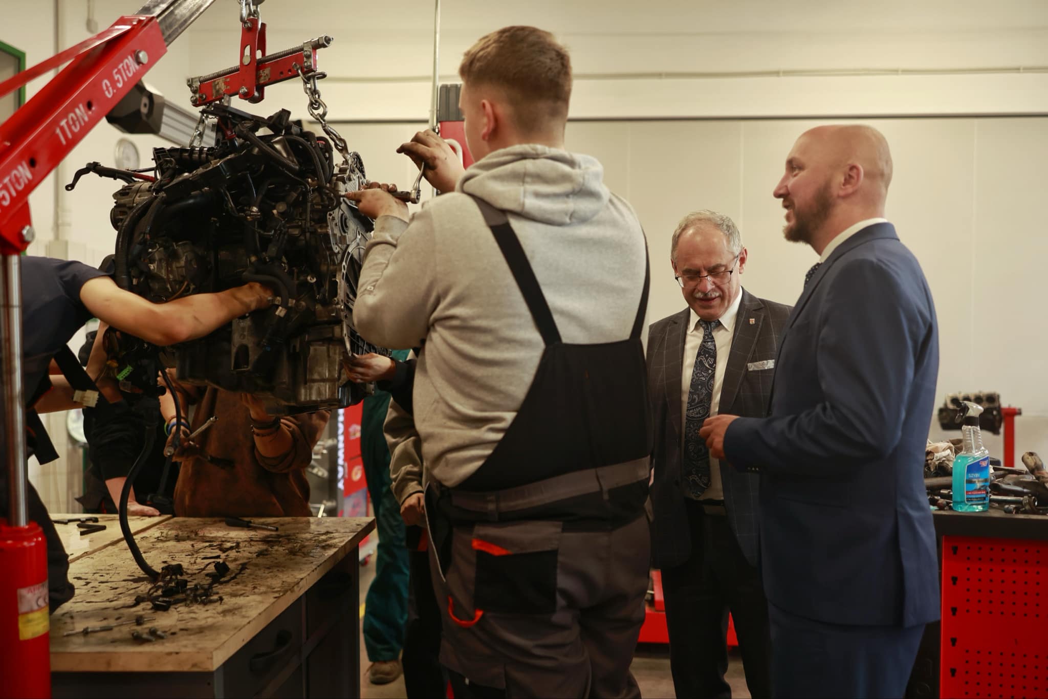 Marszałek Łukasz Prokorym z uczniem i prezydentem Suwałk w szkolnym garażu