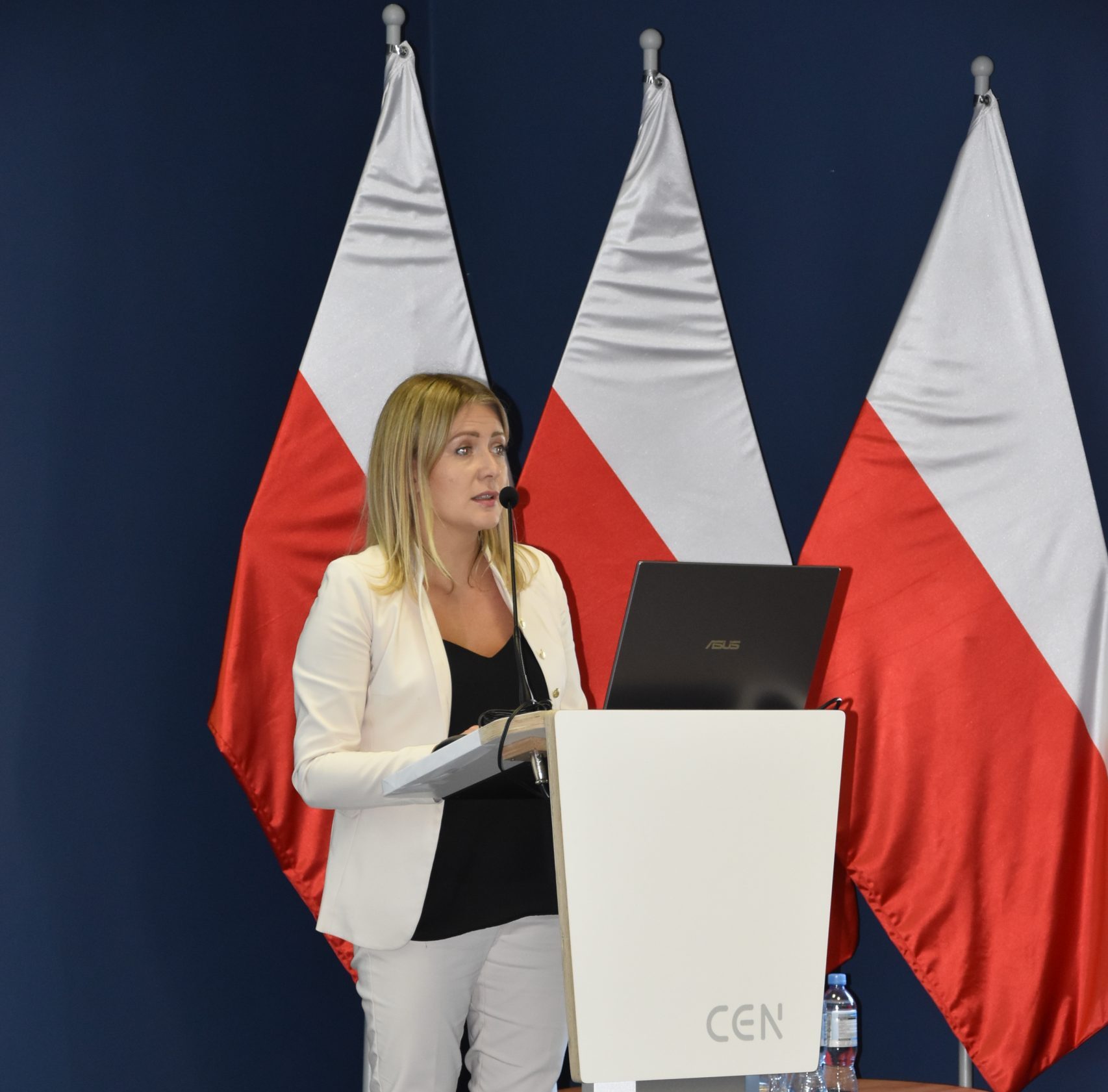 Karolina Perkowska Dyrektor Departamentu Zarzadzania Funduszami i Programami na tle flag Polski