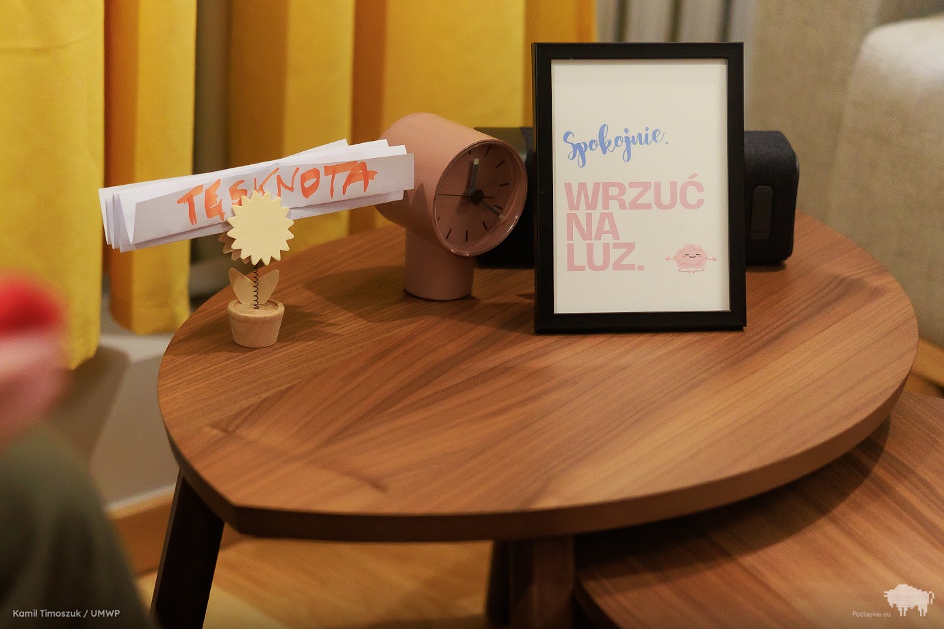 Zbliżenie na stolik, na którym stoi obrazek z pozytywnym hasłem
