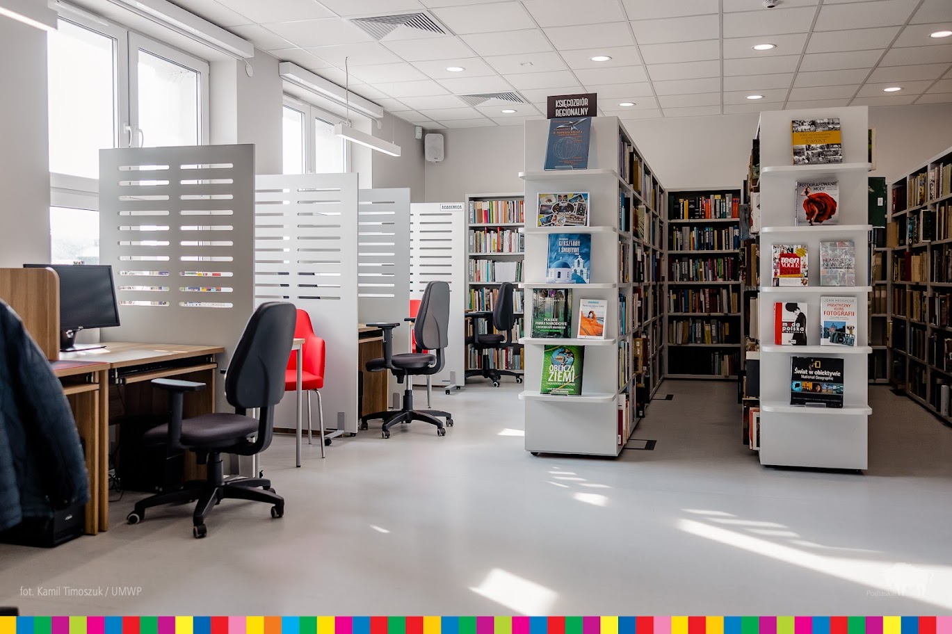 Sala biblioteczna z regałami pełnymi książek