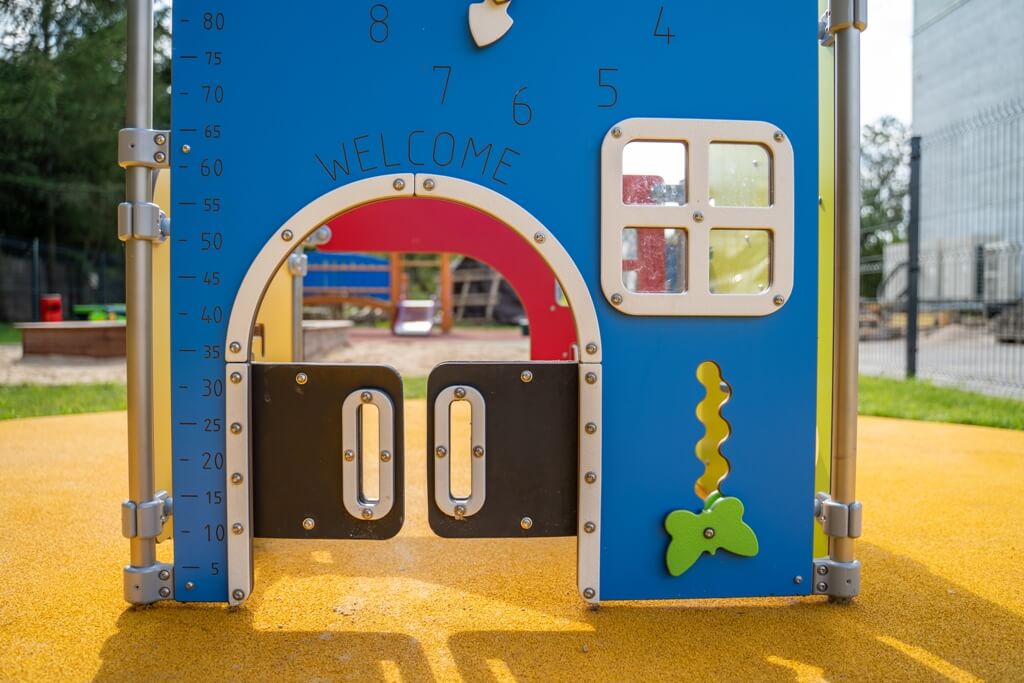 Kolorowy domek z zabawkami zręcznościowymi na placu zabaw przy żłobku