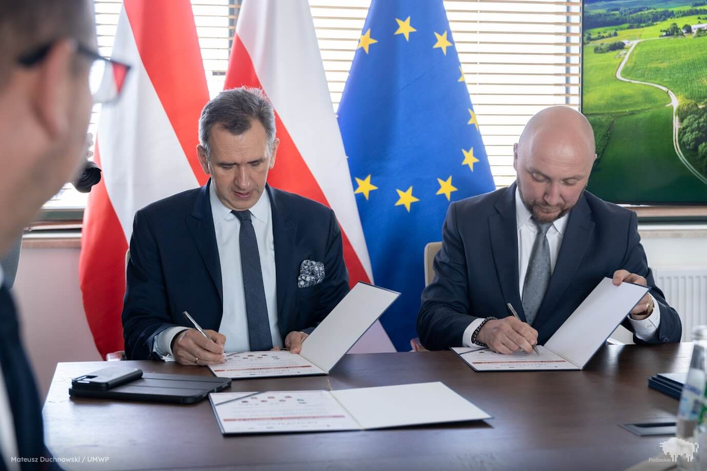 Dwóch mężczyzn podpisuje dokumenty