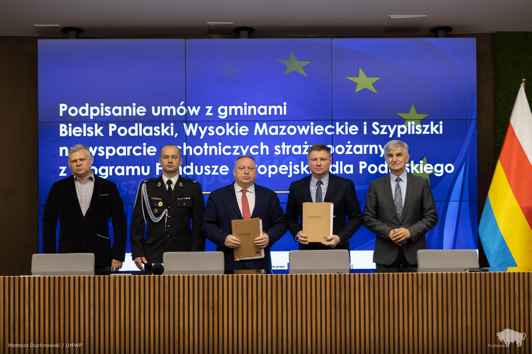 Grupa osób pozuje do pamiątkowego zdjęcia.
