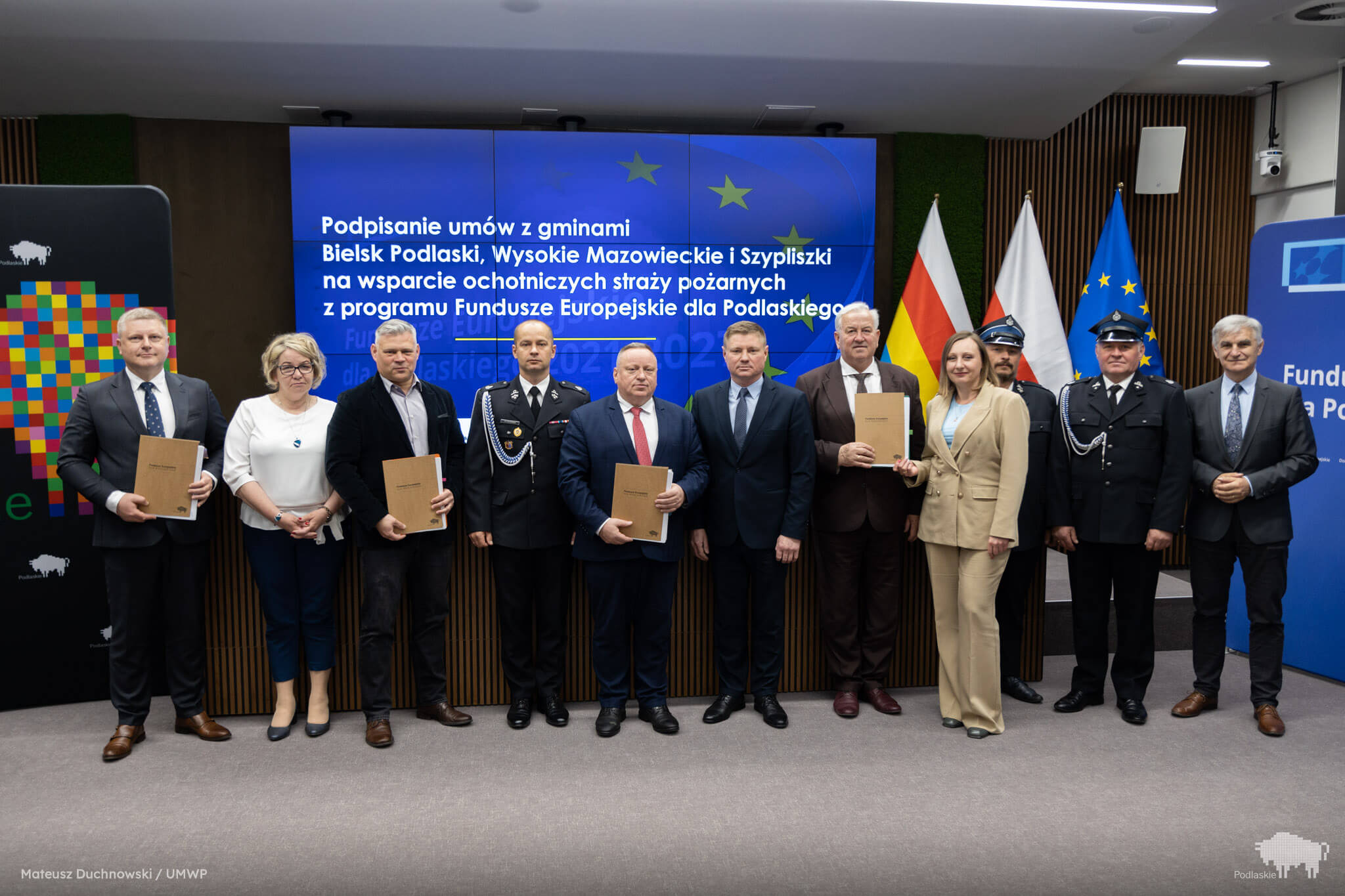 Grupa osób pozuje do pamiątkowego zdjęcia.