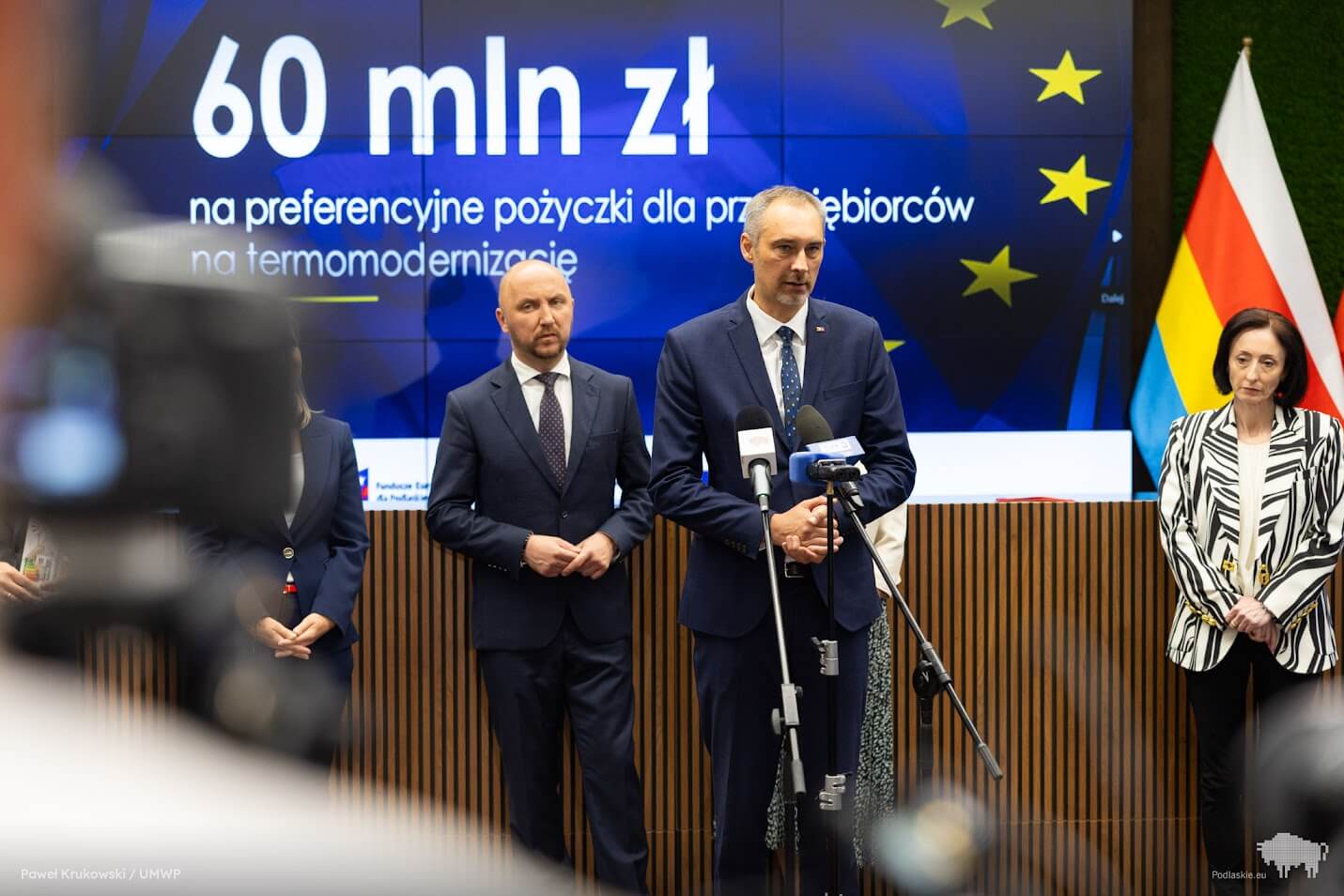 Mężczyzna mówi do mikrofonu podczas konferencji prasowej