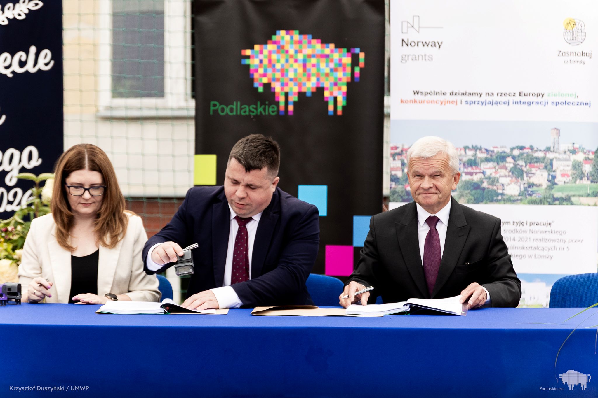 Grupa osób pozuje do pamiątkowego zdjęcia.
