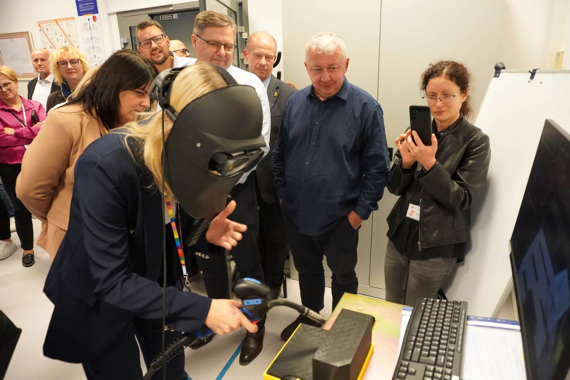 Grupa osób przy symulatorze spawania