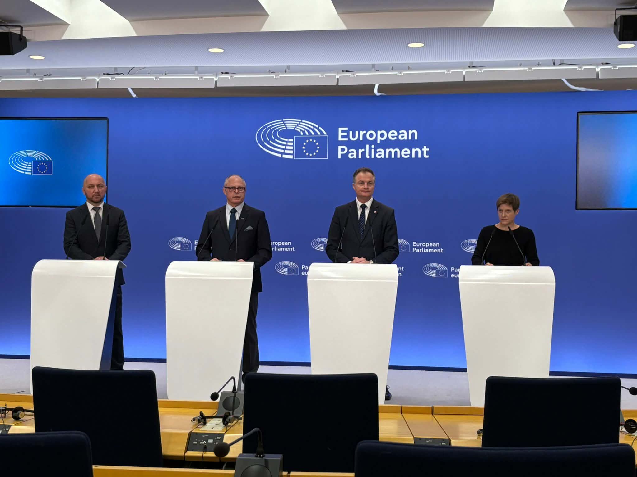 Grupa osób przemawia do zgromadzonych gości.