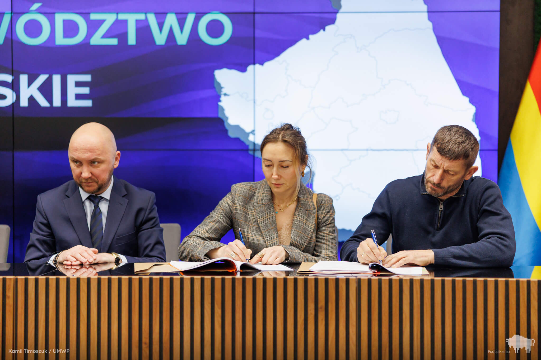 Kobieta i mężczyzna podpisują umowę o dofinansowanie