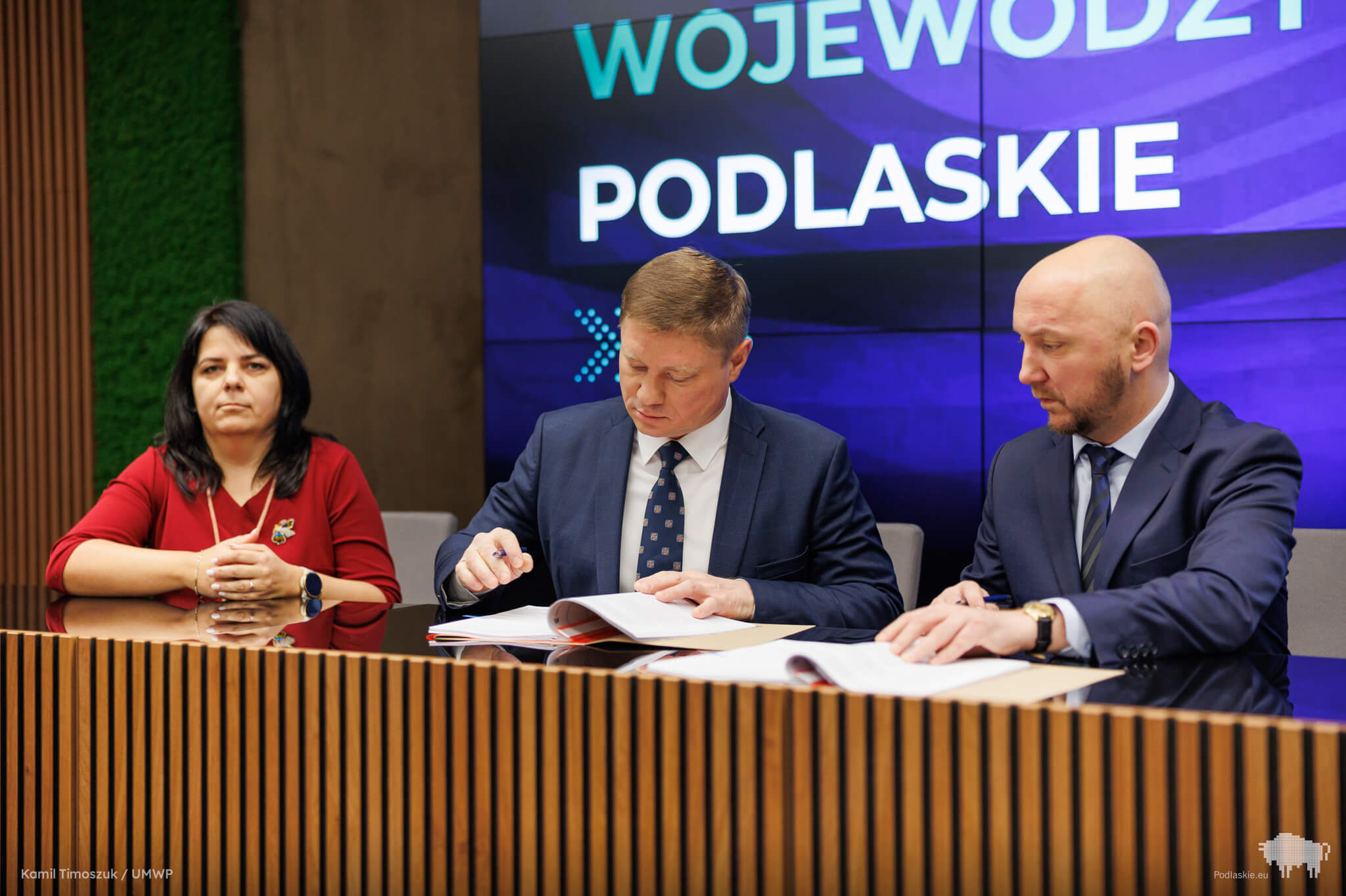 Mężczyźni podpisują dokumenty