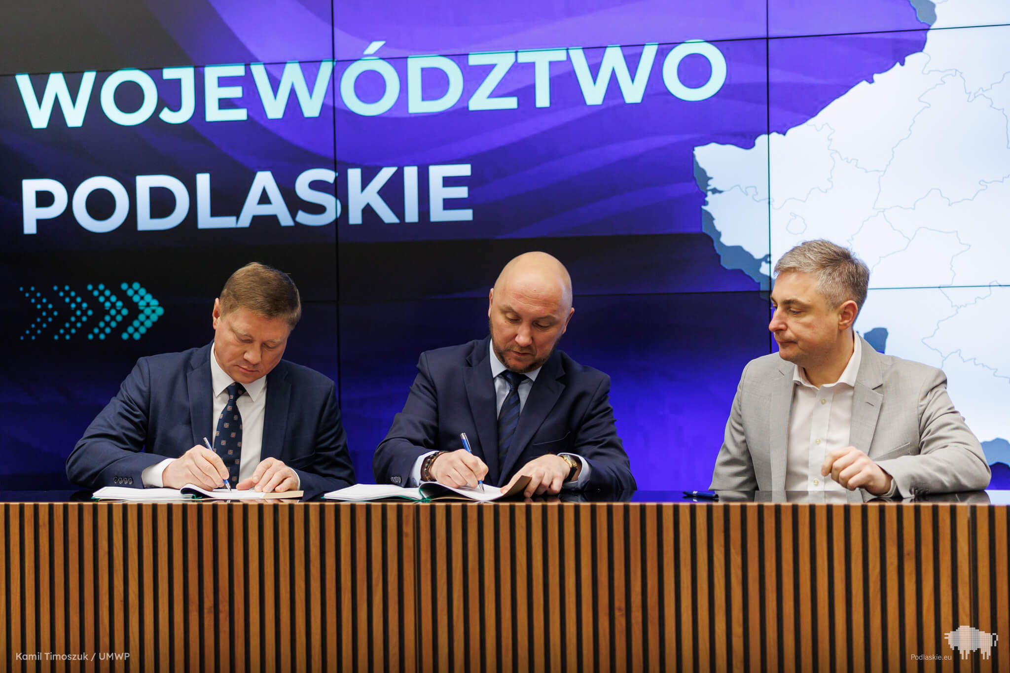 Mężczyźni podpisują dokumenty