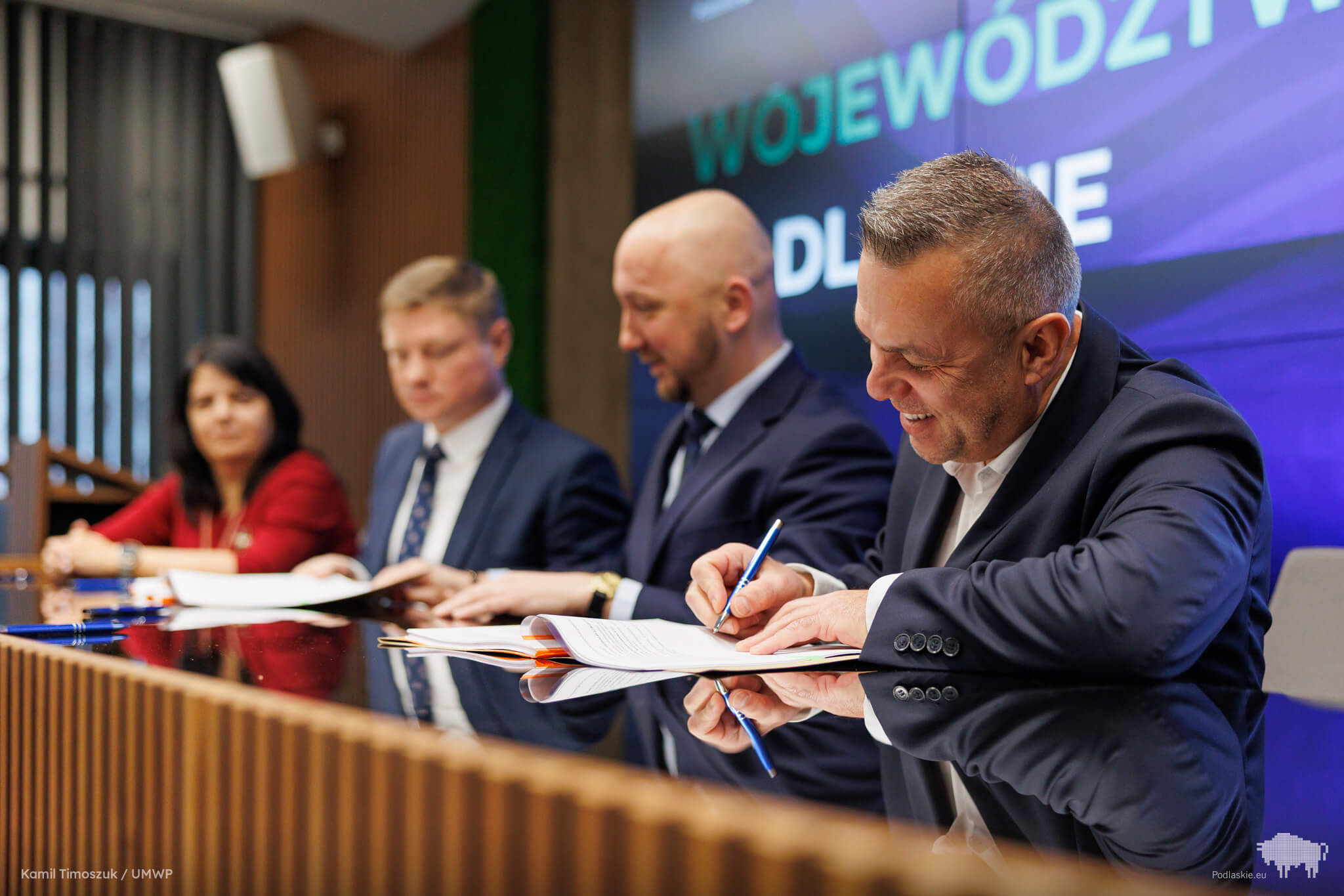 Mężczyźni podpisują dokumenty