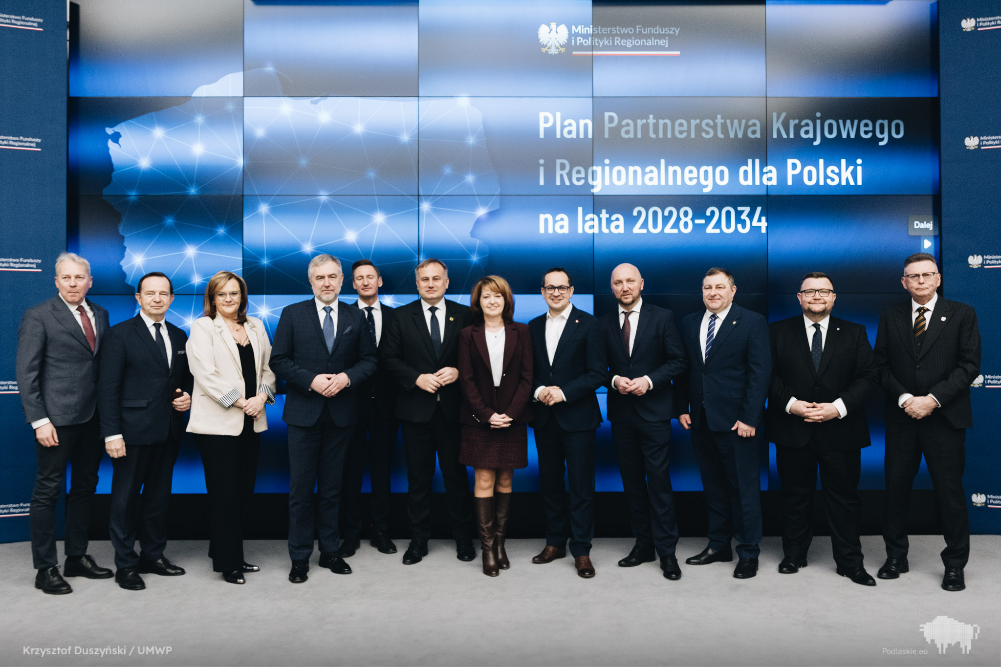 Grupa osób pozuje do pamiątkowego zdjęcia.