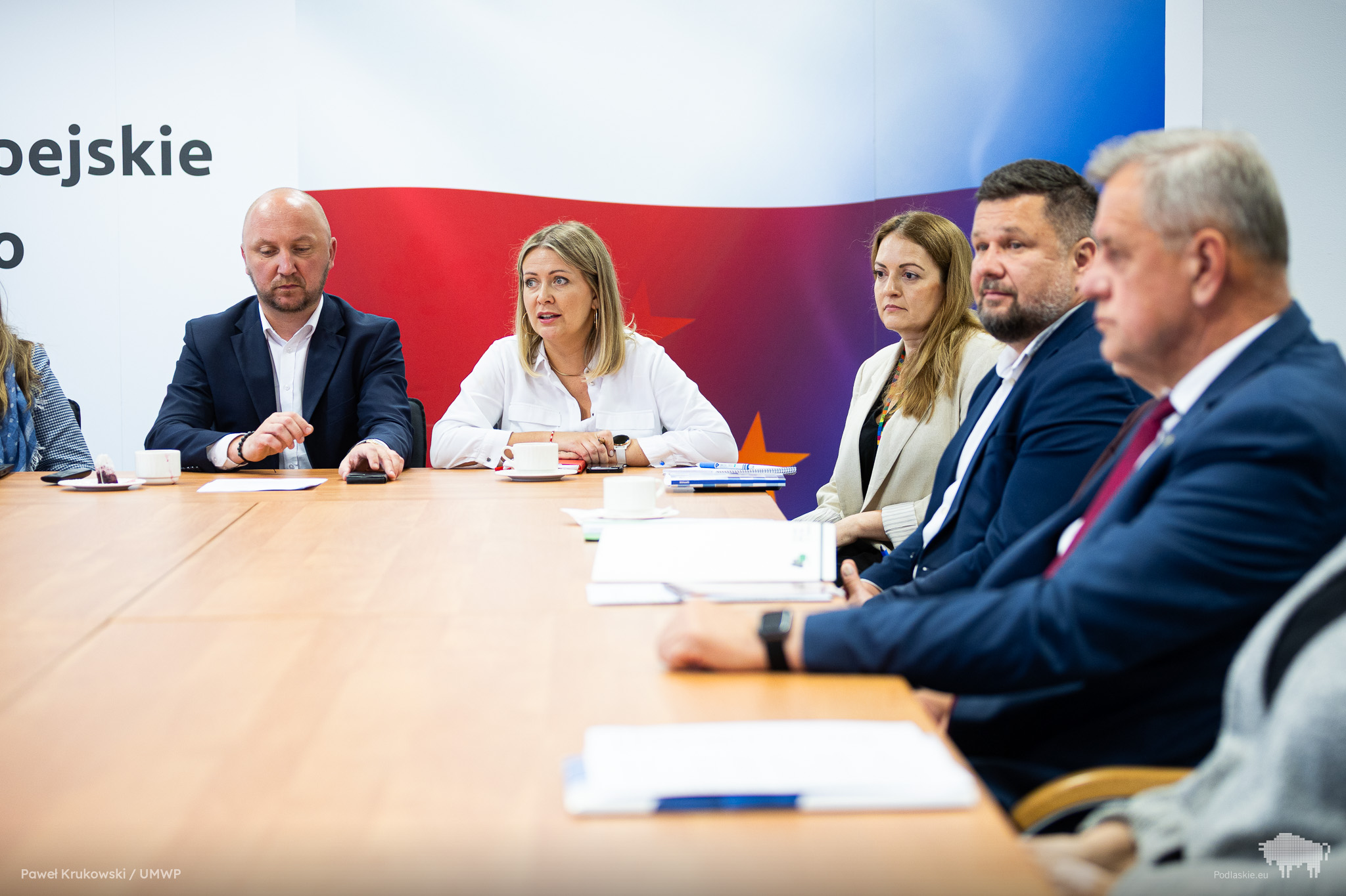 Grupa osób słucha przemówienia.