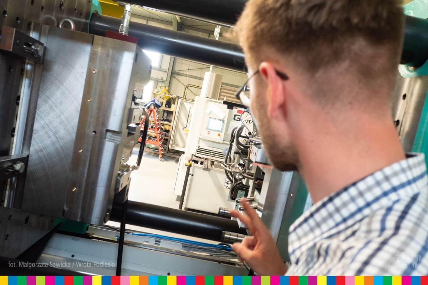 Pracownik pokazuje element nowoczesnej linii technologicznej