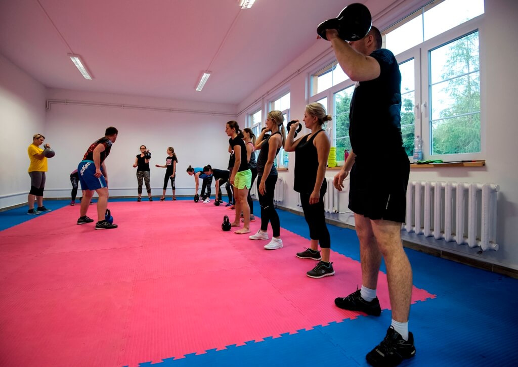 Uczestnicy zajęć fitness ćwiczą w sali centrum