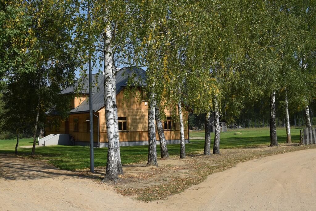 Widok z zewnątrz na drewniany, dwupiętrowy budynek szkoły z Kalinowa