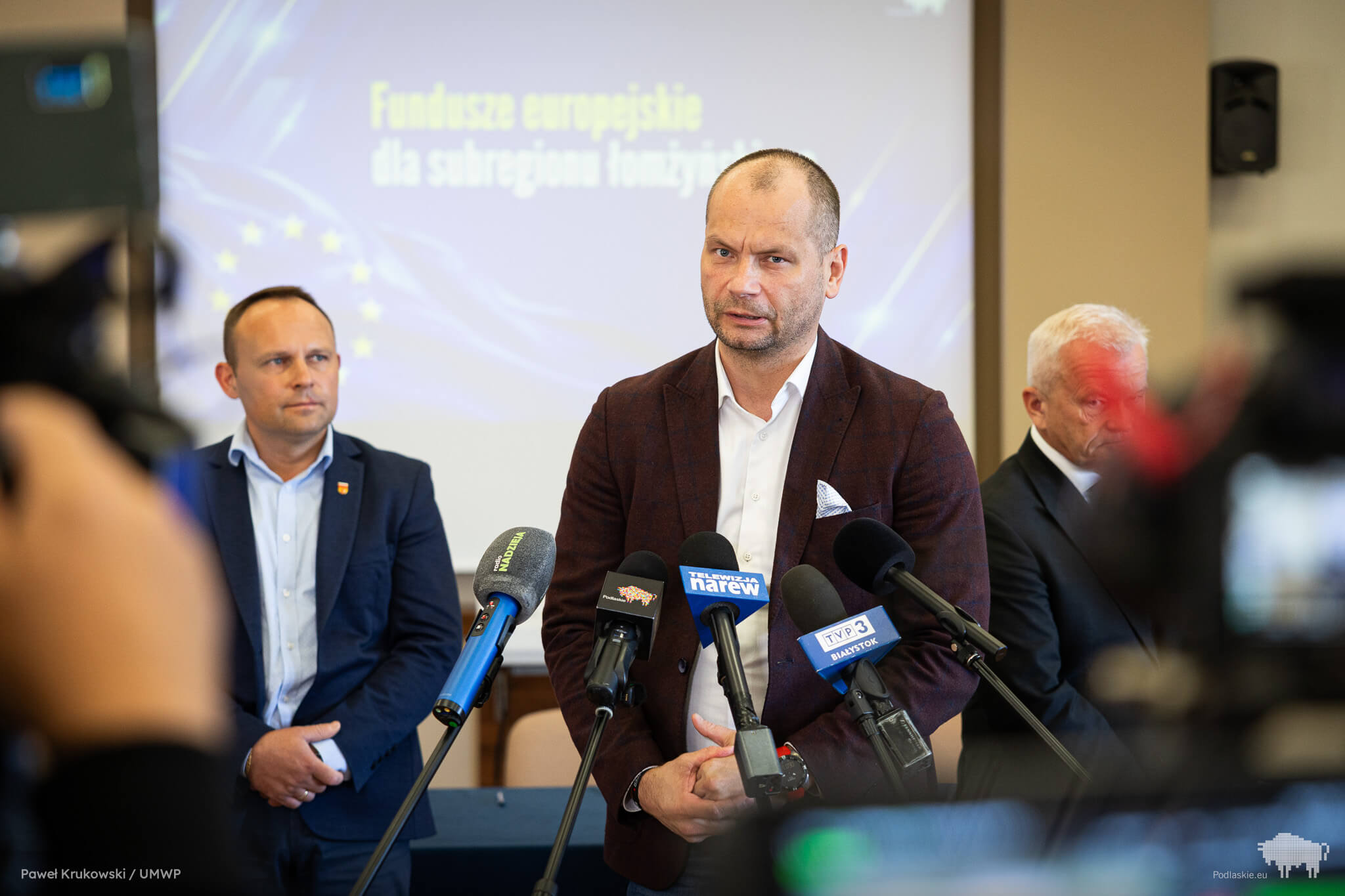 Mężczyzna mówi do mikrofonu podczas konferencji prasowej