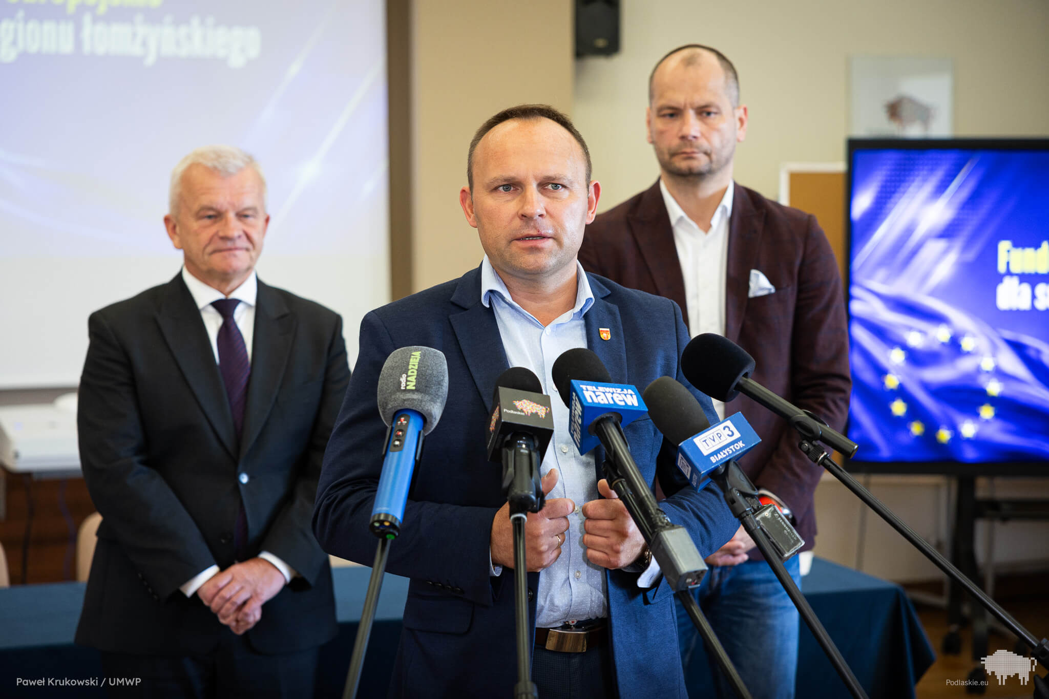 Mężczyzna mówi do mikrofonu podczas konferencji prasowej