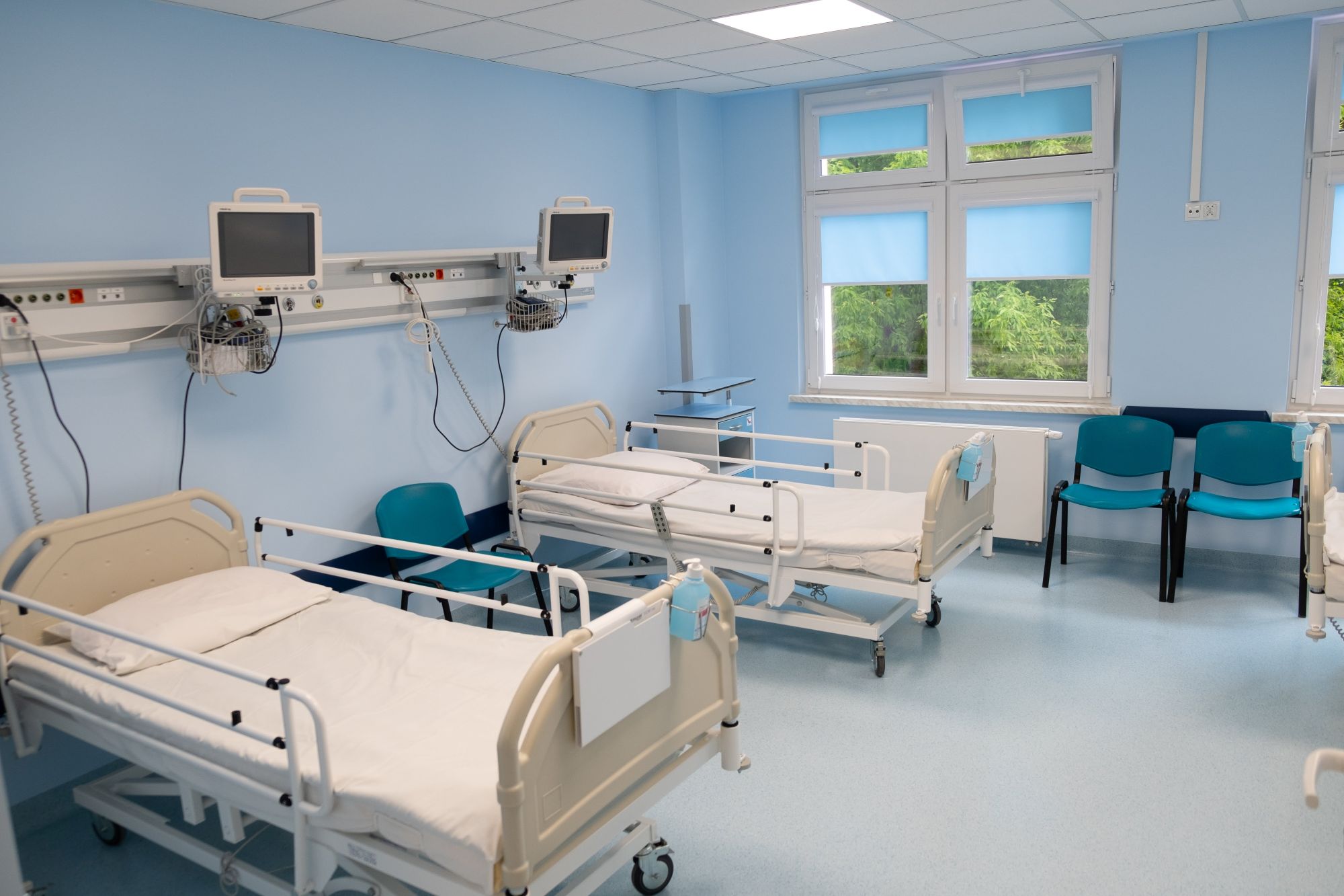 Sala szpitalna z dwoma lóżkami i panelem urządzeń medycznych do monitorowania stanu pacjenta