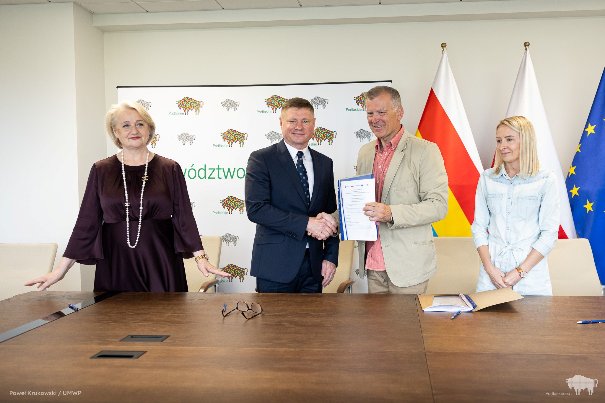 Grupa osób pozuje do pamiątkowego zdjęcia.