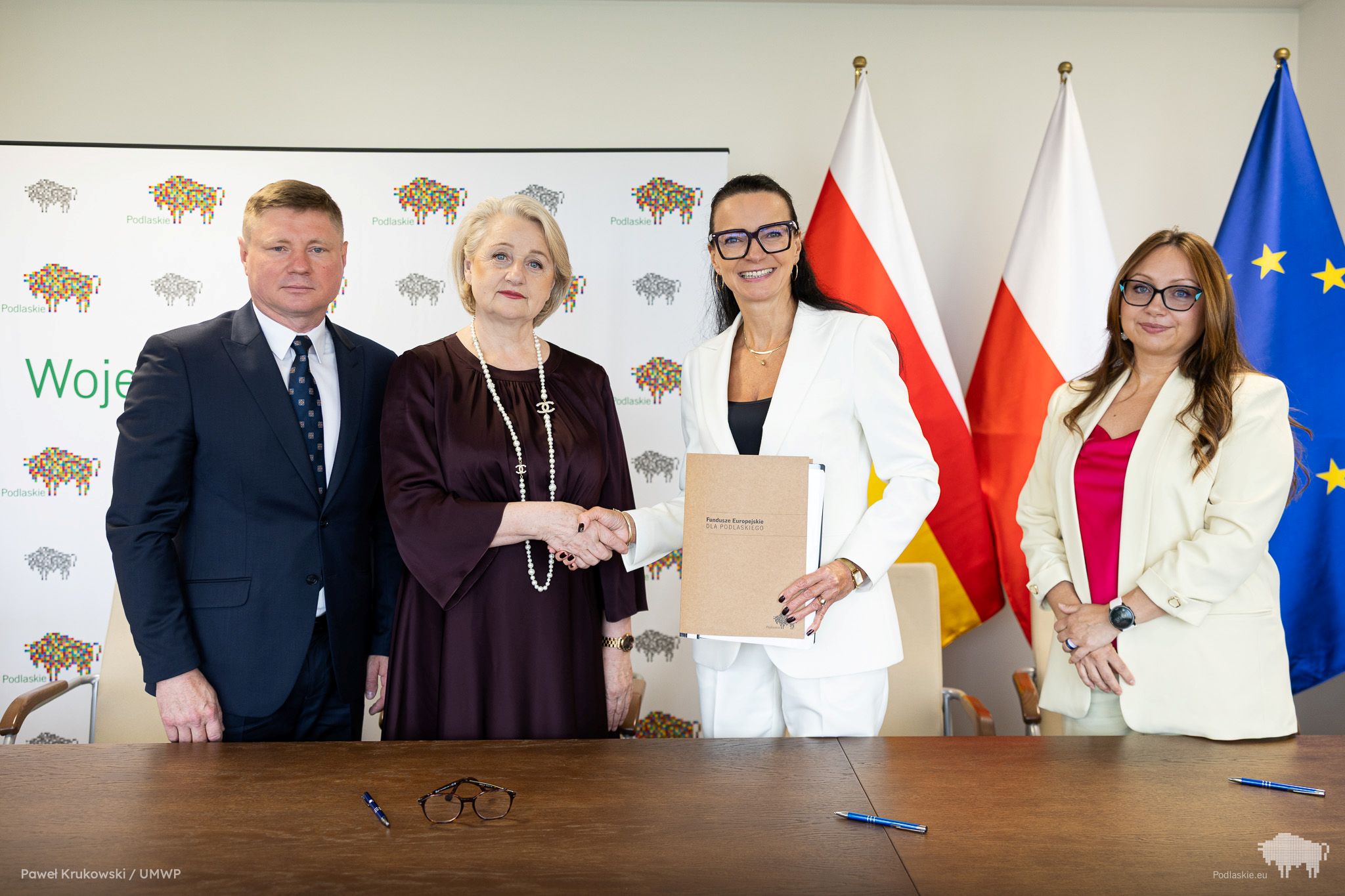 Grupa osób pozuje do pamiątkowego zdjęcia.