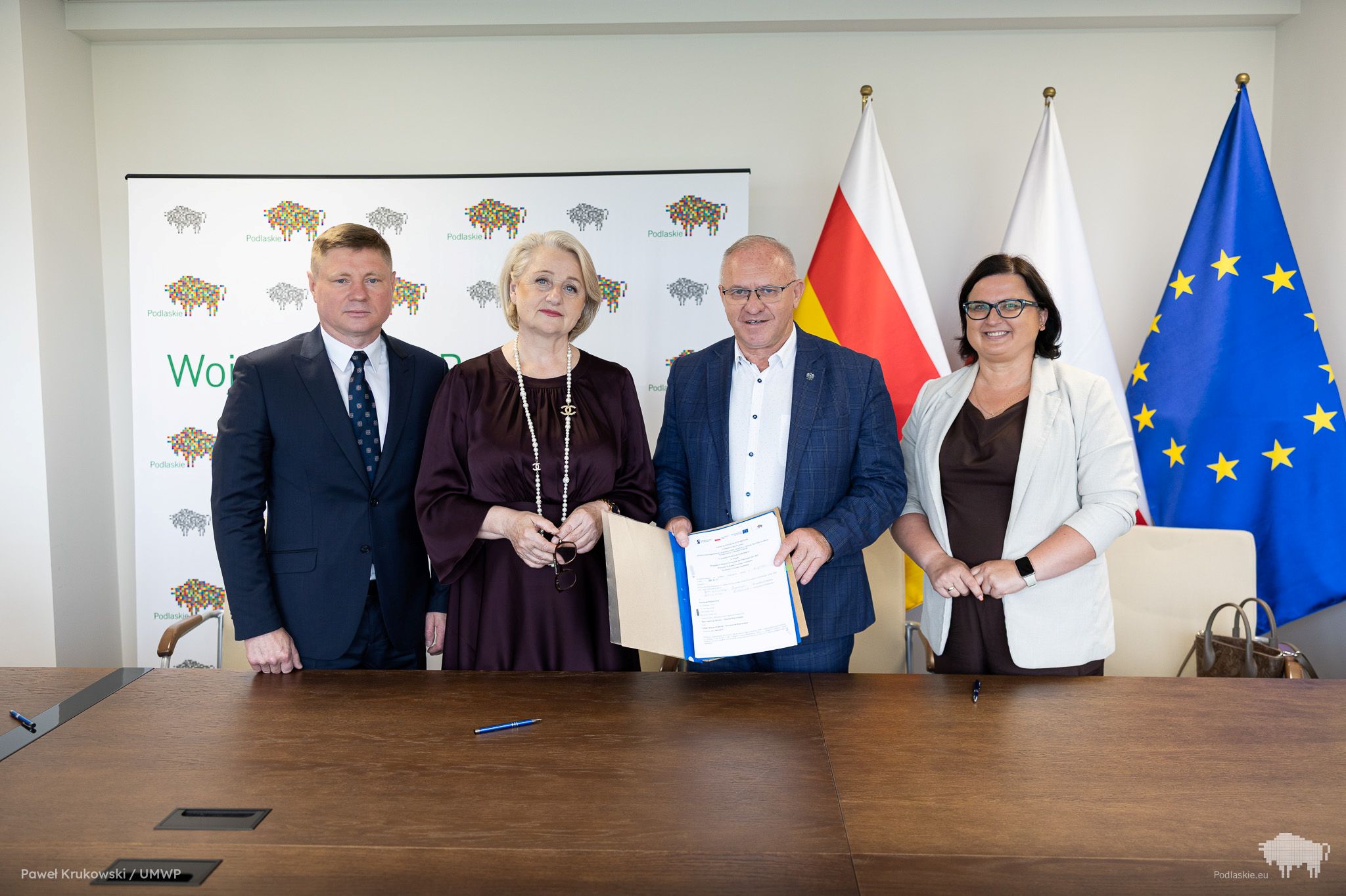Grupa osób pozuje do pamiątkowego zdjęcia.