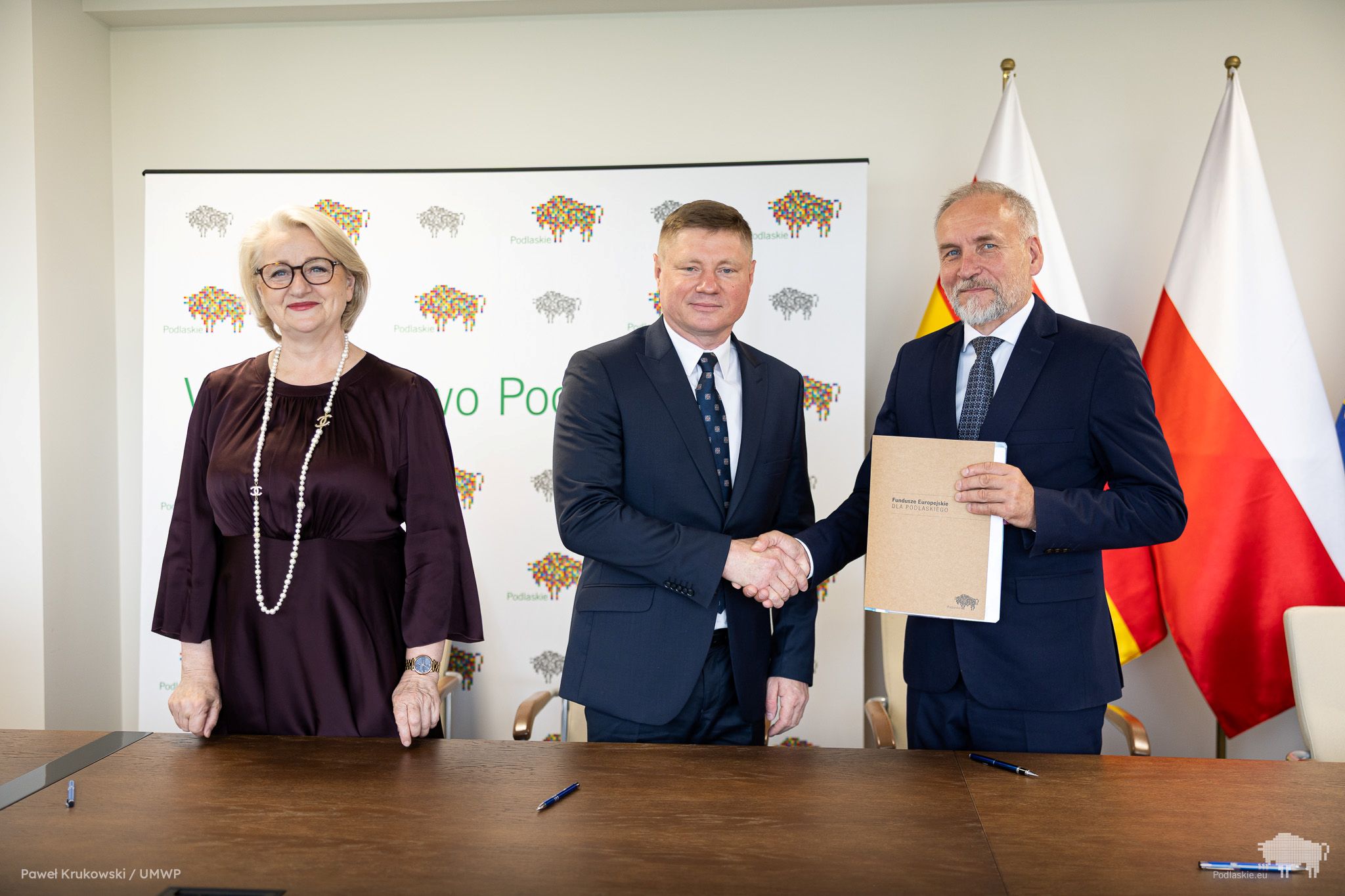 Grupa osób pozuje do pamiątkowego zdjęcia.