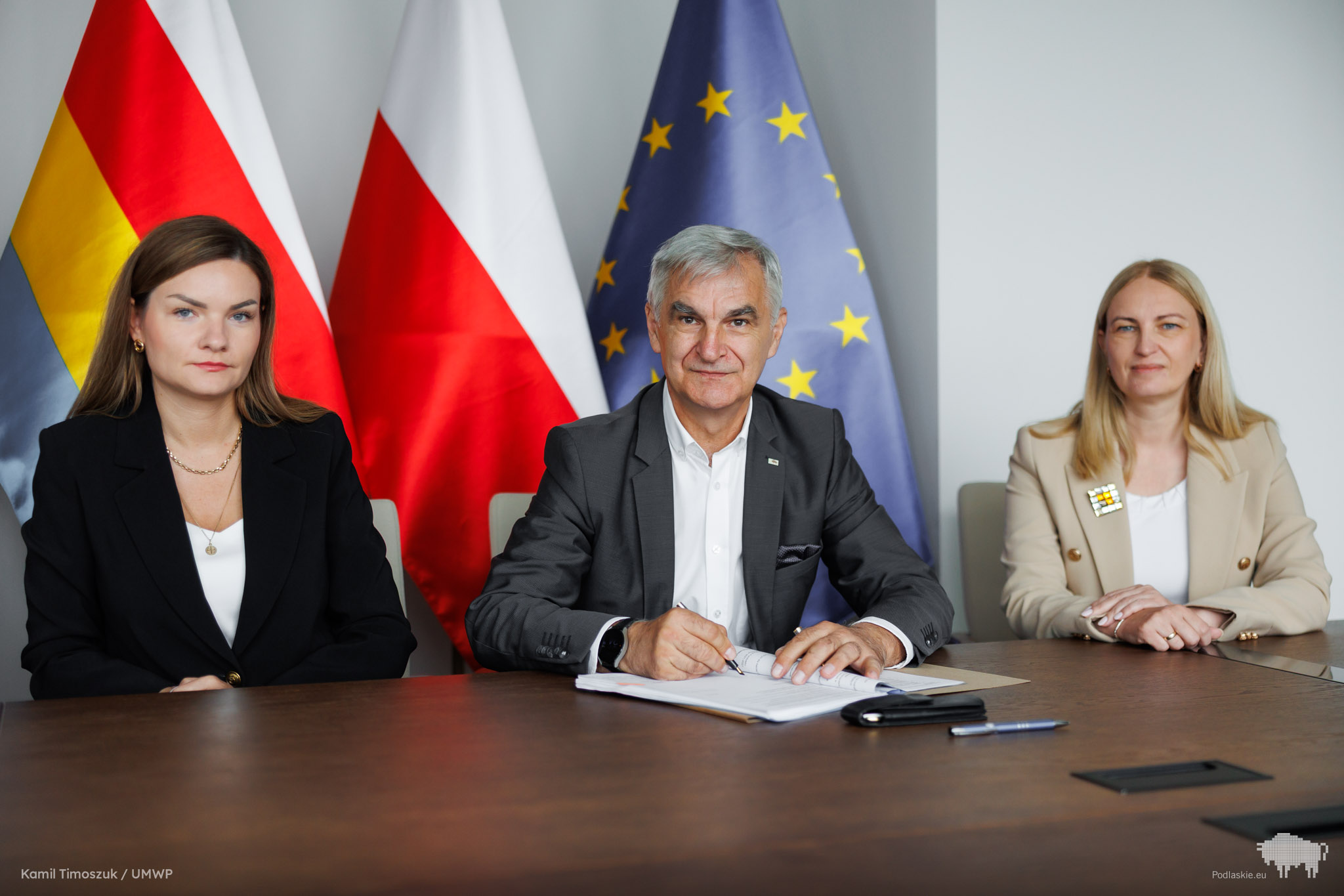 Grupa osób pozuje do pamiątkowego zdjęcia.