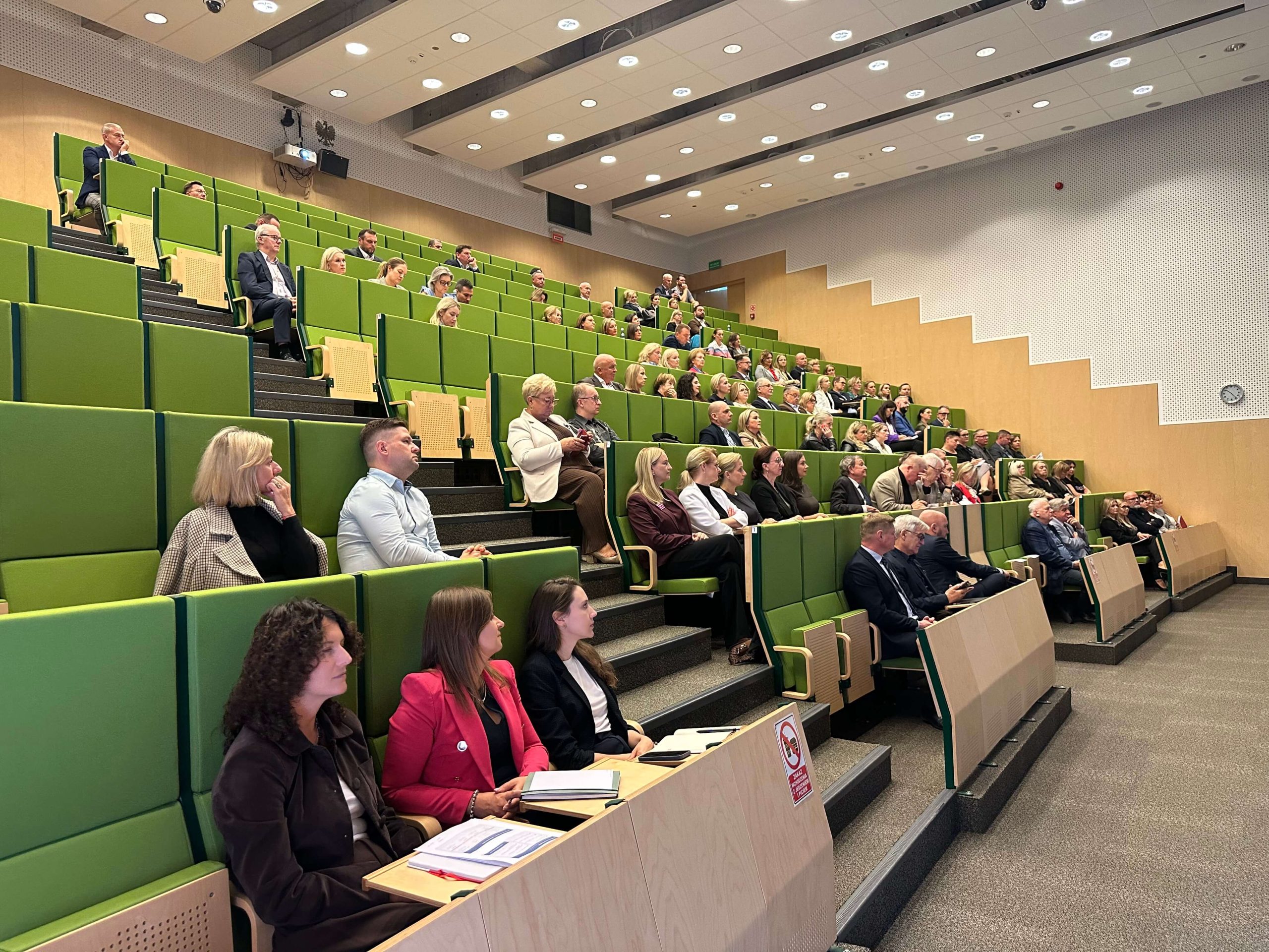 Uczestnicy spotkania siedzą na sali konferencyjnej