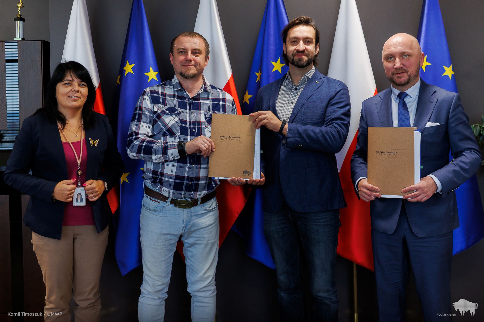 Grupa osób pozuje do pamiątkowego zdjęcia.