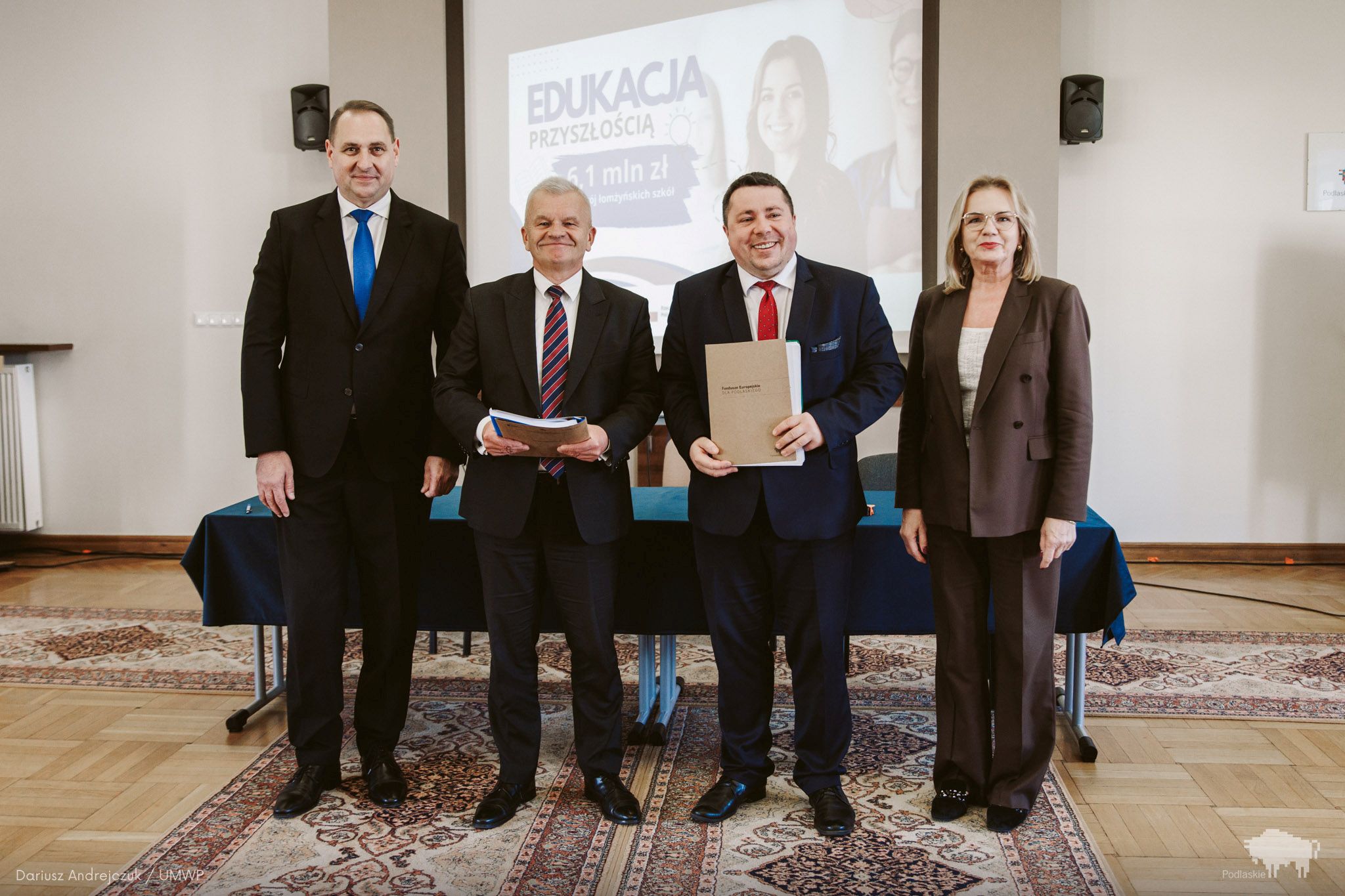 Grupa osób pozuje do pamiątkowego zdjęcia.