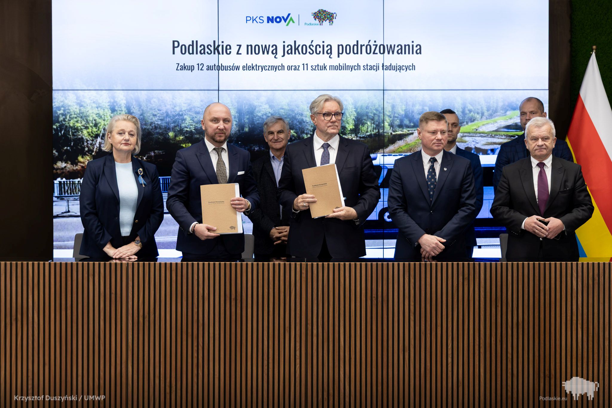 Grupa osób pozuje do pamiątkowego zdjęcia.